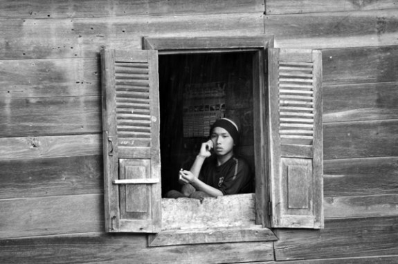 duduk di balik jendela rumah tua