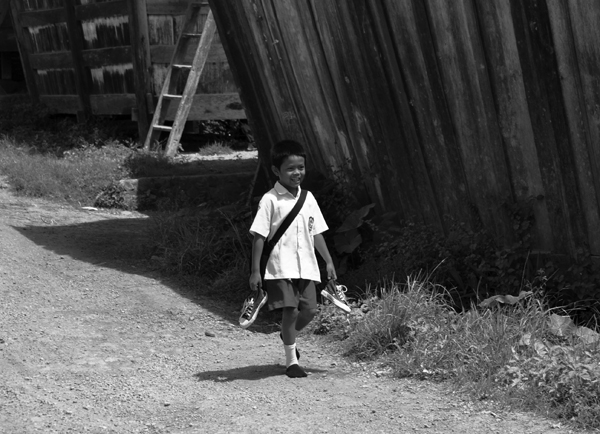 Hemat Sepatu - anak lelaki pulang sekolah menjinjing sepatu (lokasi: Lempur Mudik)
