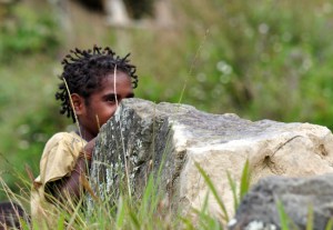 gadis cilik bersembunyi di balik batu