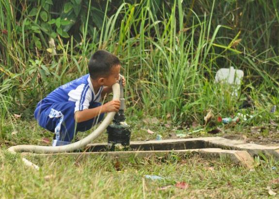 Minum sumber air bersih di samping sekolah