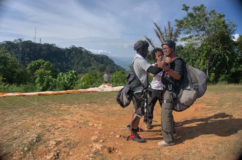 persiapan paralayang - mengenakan body hardness dan helm