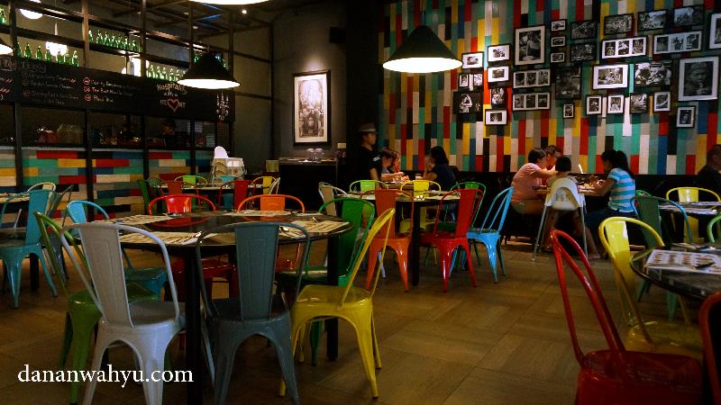 Kursi warna-warni menyemarakan ruangan didominasi warna hitam