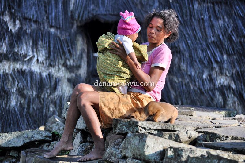 Berjemur - Wae Rebo, Flores. Udara pegunungan terasa segar di paru-paru, tapi sinar matahari sangatlah penting bagi kesehatan, konon mengandung pro vitamain. Ibu muda tak segan membawa buah hatinya meninggalkan Mbaru Niang, duduk di atas batu-batu belah.