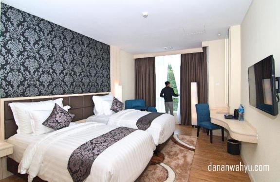 Kamar Aston Batam Hotel & Residence dengan ornamen batik Melayu di dinding 