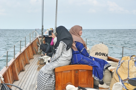 Dua gadis berpakaian Melayu berlayar untuk menyaksikan perlombaan yacht.