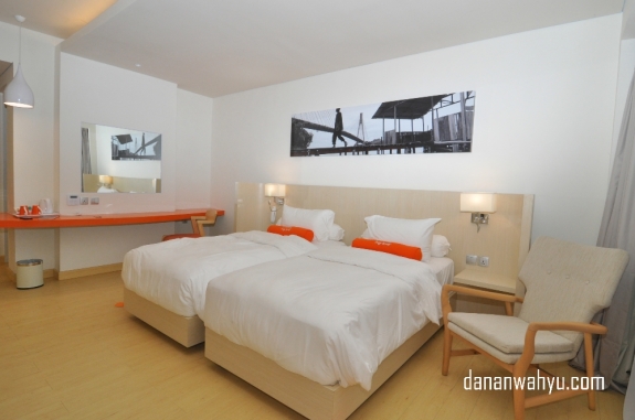Desain interior kamar didominasi warna putih dengan oranye , krem dan hitam menjadi pemanis.